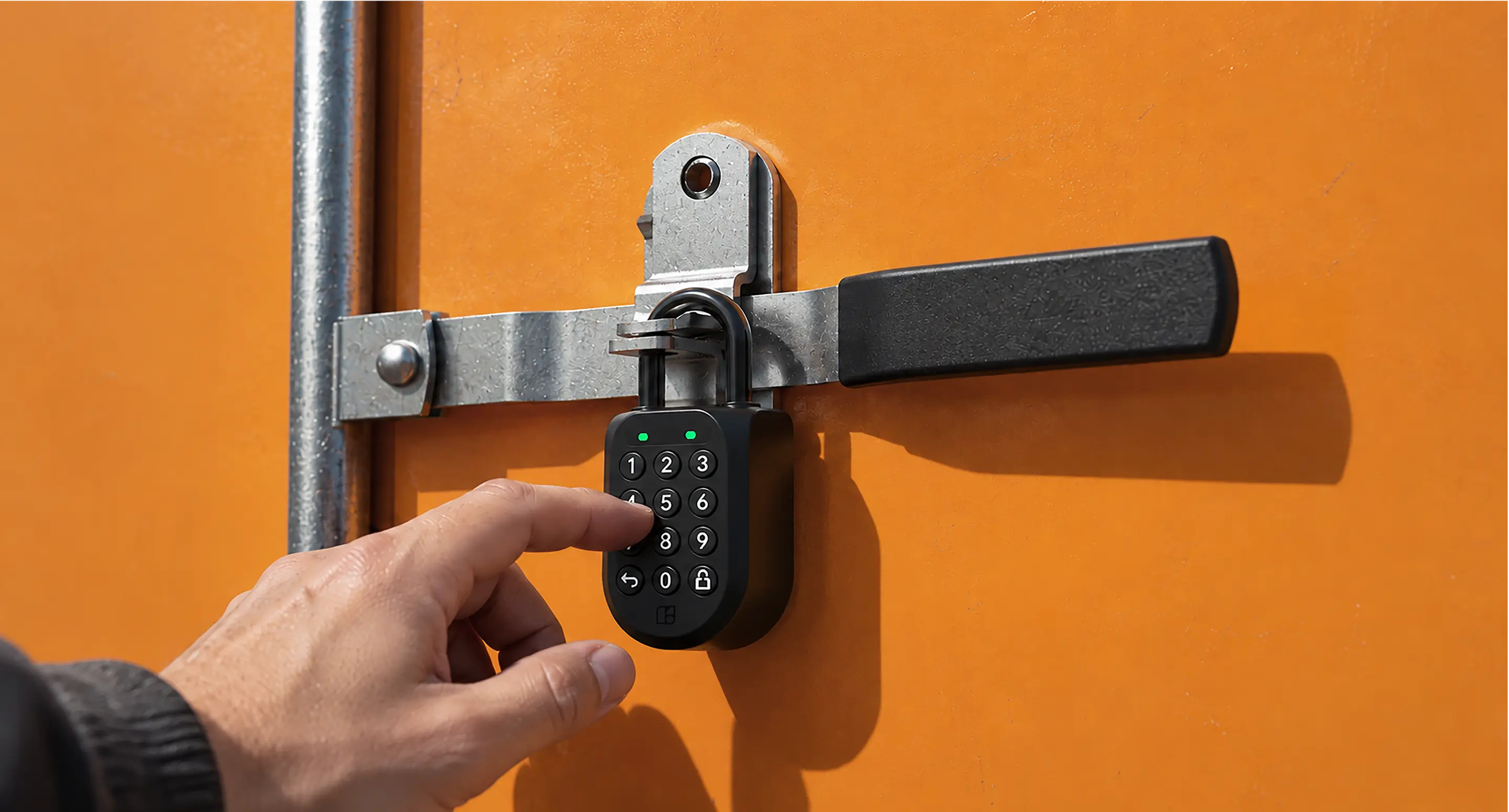 A hand entering a PIN on an igloo Padlock 2 locking the latch bar of an orange shipping container