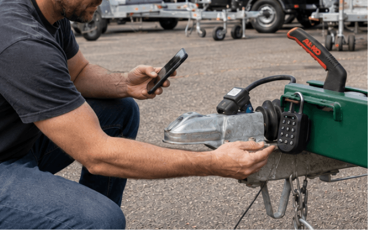 A customer entering a PIN on an igloo smart padlock to unlock a hire trailer