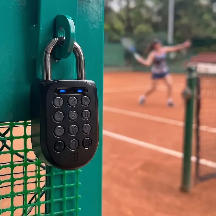 An igloo smart padlock securing the gate of a self-serve tennis court