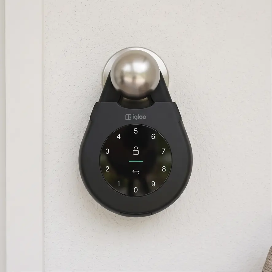 An igloo Keybox 3 hanging from a round door knob on a white door