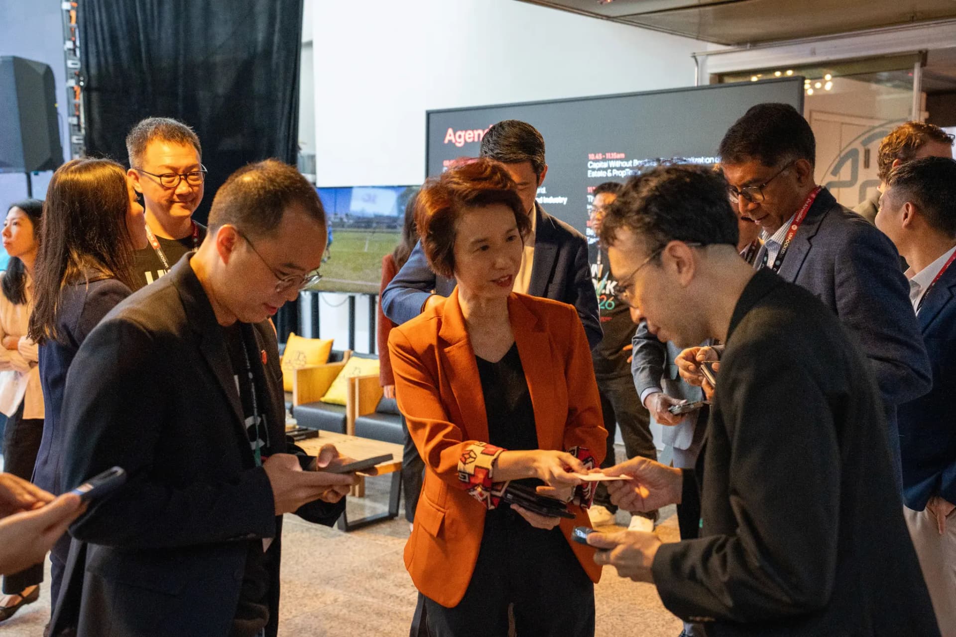 Attendees networking and exchanging contacts on their phones at UNLOCKED26