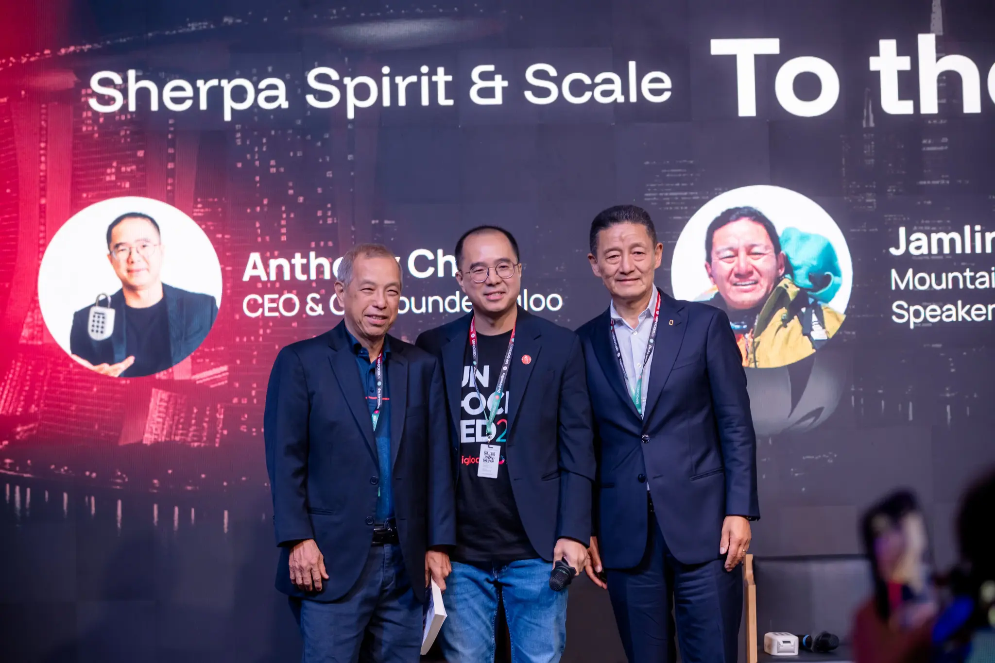 igloo CEO and co-founder Anthony Chow on stage with two guests at UNLOCKED26