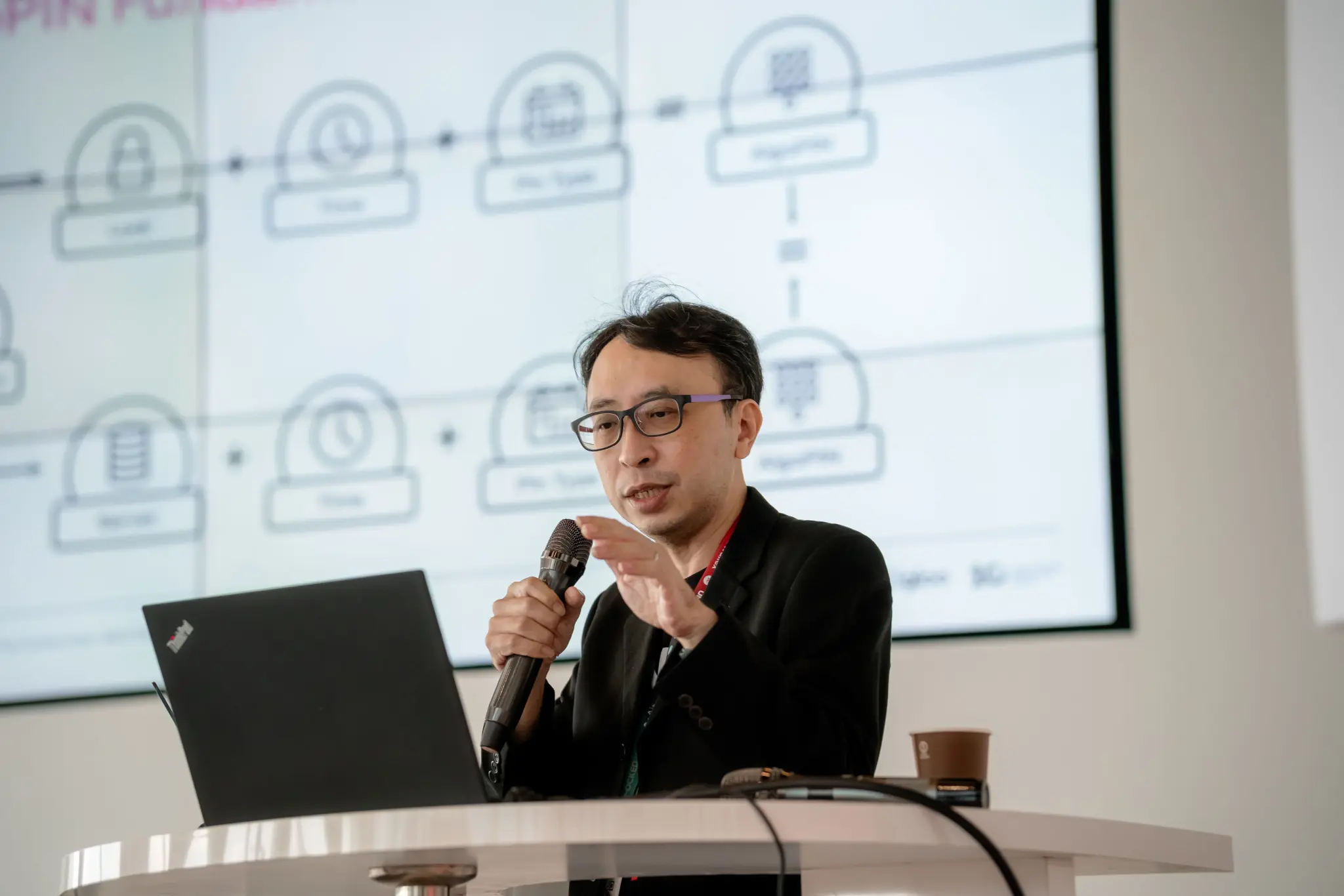 Speaker presenting an access workflow diagram from a lectern at UNLOCKED26
