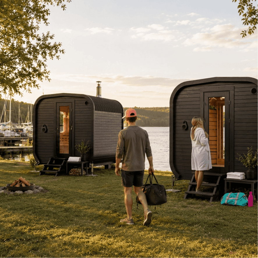 Guests arriving at two unattended waterfront sauna cabins at sunset