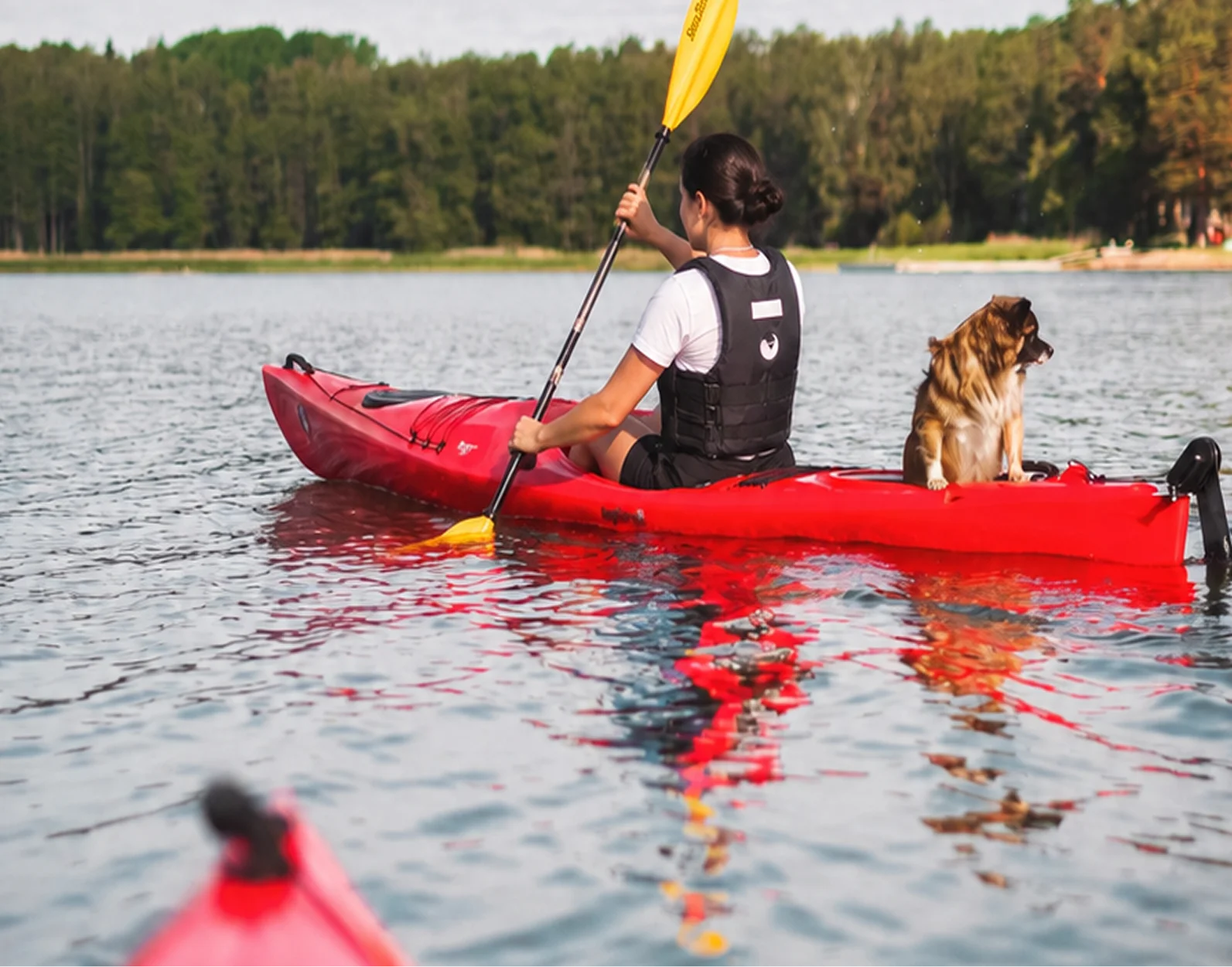 A woman paddling a kayak collected from a self-serve rental rack